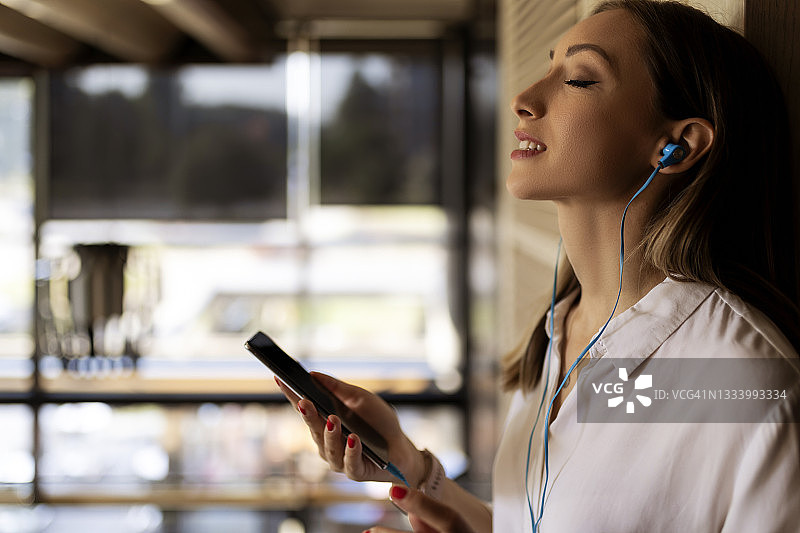 女商人于咖啡休息时间听音乐图片素材