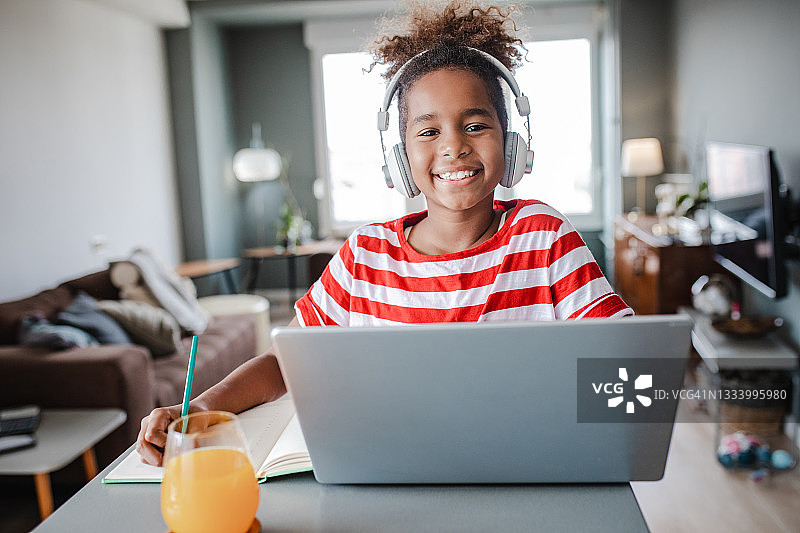 在家用笔记本电脑的小女孩肖像图片素材