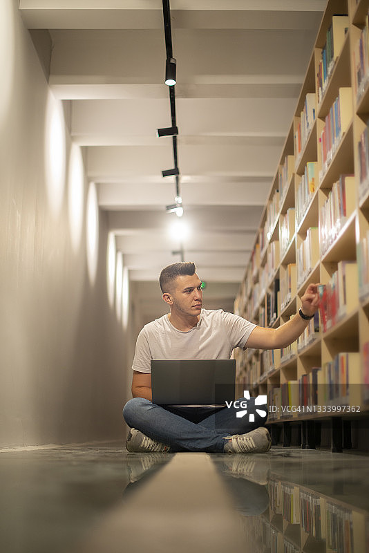 学生在城市图书馆用笔记本电脑做研究图片素材