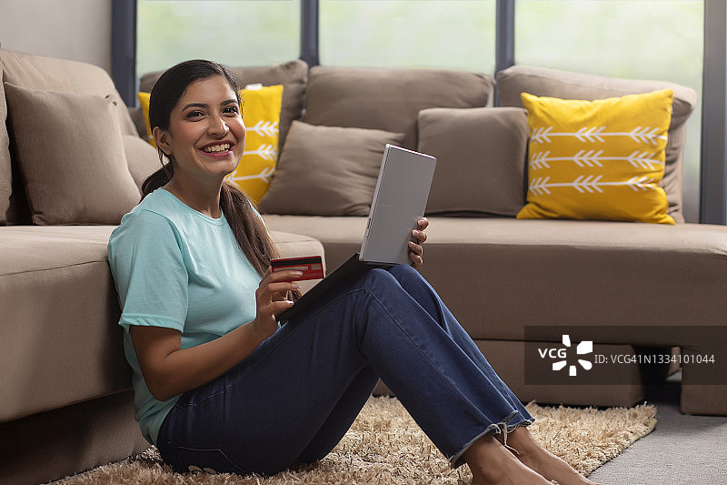 女孩用笔记本电脑和信用卡在网上购物图片素材