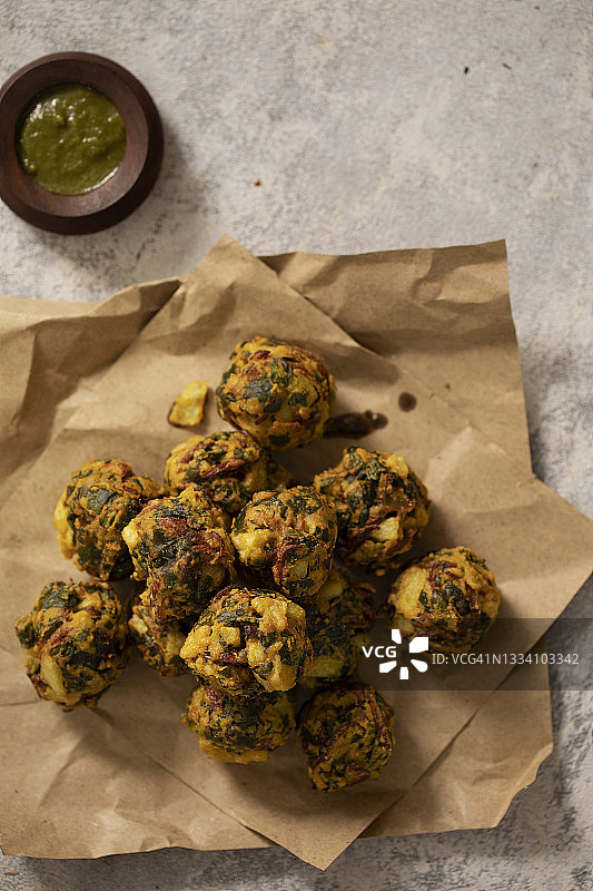 印度蔬菜油炸馅饼，配以纸上的热食和酸辣酱图片素材