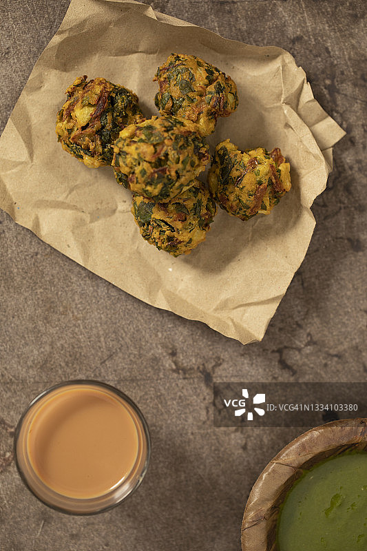 纸上盛放的油炸蔬菜饼配茶和酸辣酱图片素材