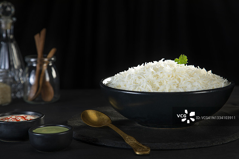 黑碗里的蒸米饭配绿色酸辣酱和凝乳图片素材