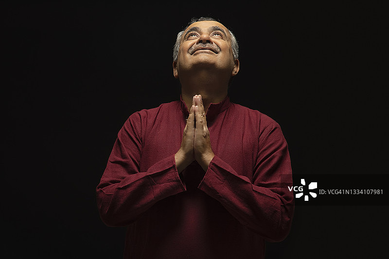 老年男人向上看并祈祷的肖像图片素材