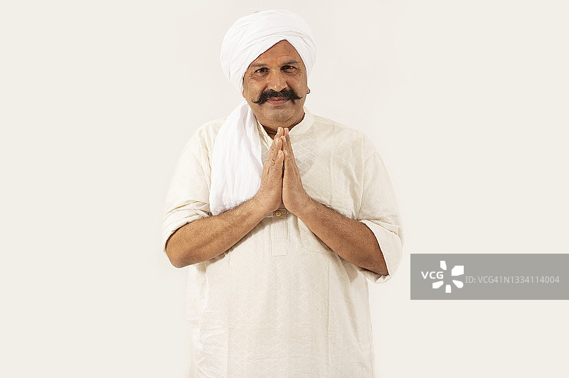 戴头巾的村民双手合十问候图片素材