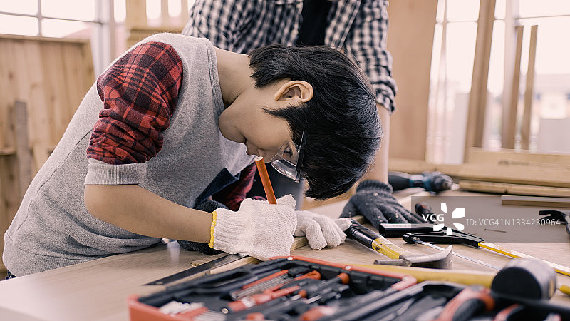 在工作室和爸爸一起工作的男孩特写图片素材