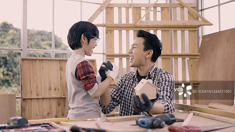 木匠和儿子在工作坊里击掌图片素材