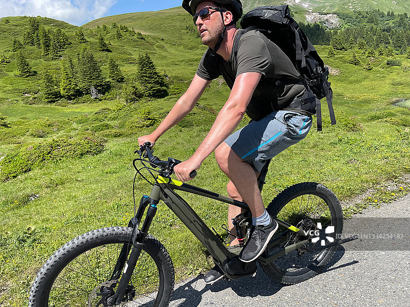 在瑞士阿尔卑斯山进行电动山地自行车运动图片素材