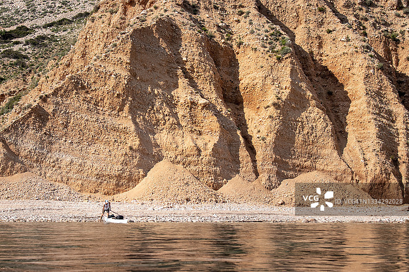 男人将海上皮划艇放入海中图片素材