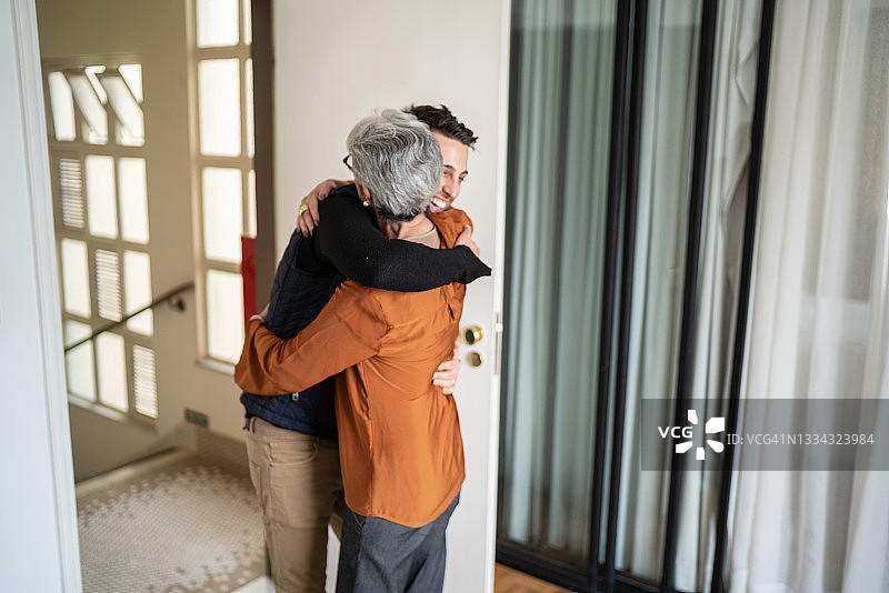 年长的妇女在家迎接儿子图片素材