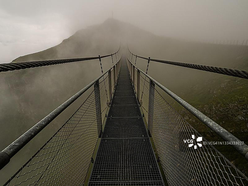 奥地利巴德加斯坦施图伯科格尔雾中的悬索桥图片素材