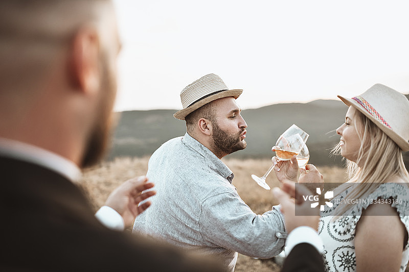 牧师在户外婚礼上为饮用葡萄酒的夫妇主持仪式图片素材