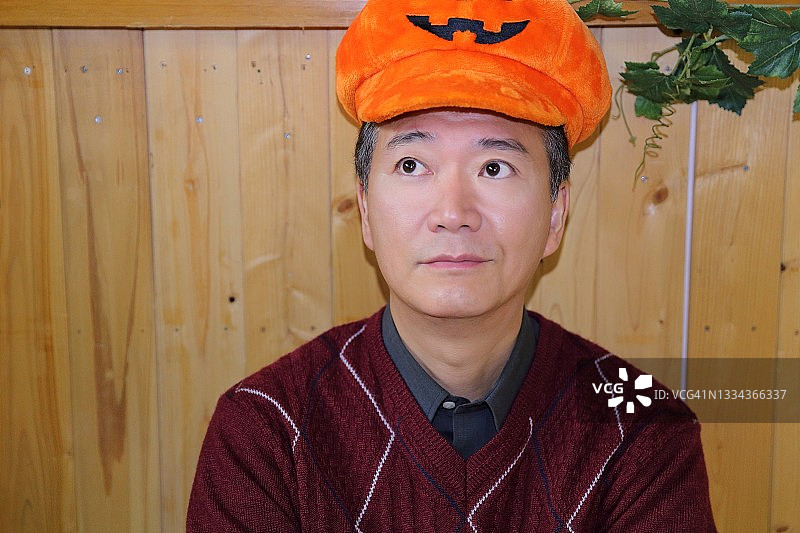 戴着万圣节南瓜帽的日本男人肖像图片素材