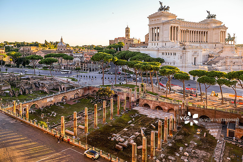 温暖的日落光芒照亮了罗马的图拉真广场，背景是维托里亚诺图片素材