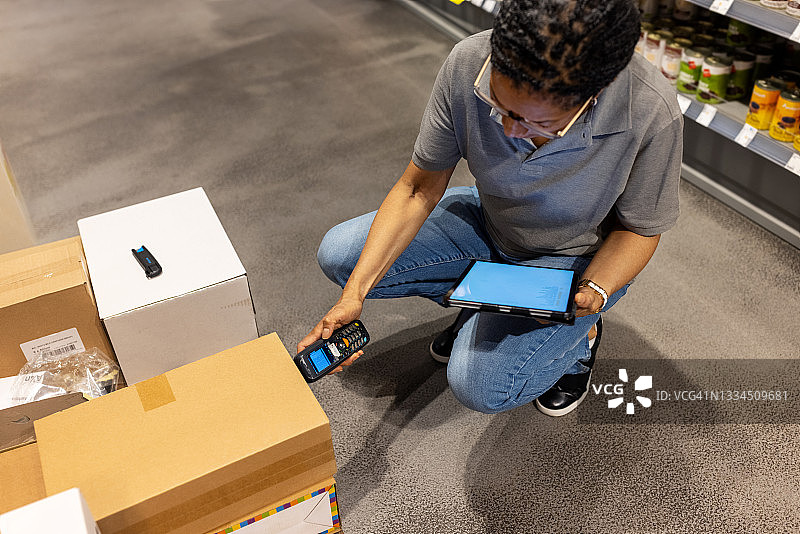 超市工作人员扫描纸箱上的条形码图片素材