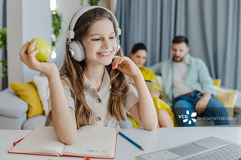 在家学习并拿着苹果的可爱女孩图片素材