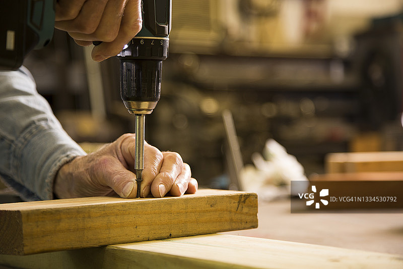 在工作室里进行小项目的年长男人图片素材