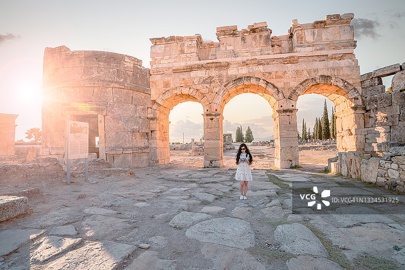 在希拉波利斯古城遗址弗龙蒂努斯门前，摄影师游客正在看她的相机，棉花堡图片素材