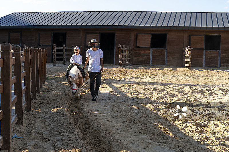 骑在马上的孩子和马夫图片素材