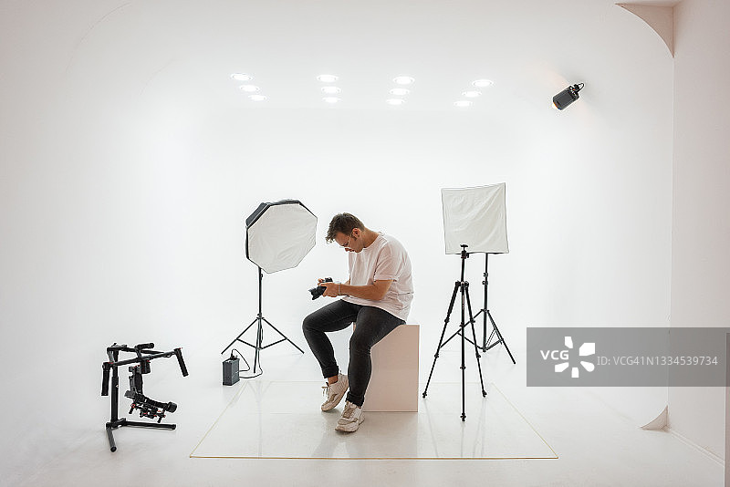 年轻摄影师在工作室选择照片图片素材