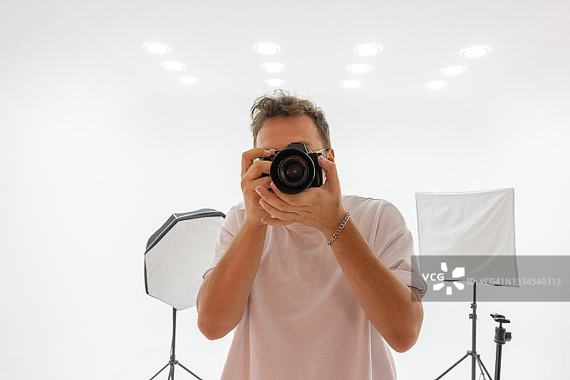 年轻男人用专业数码相机拍照图片素材