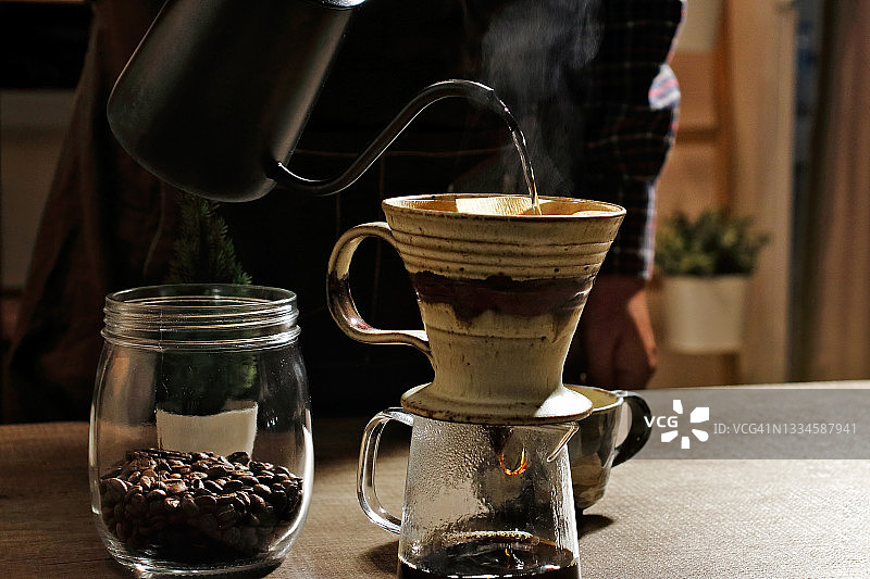 咖啡师用研磨机、咖啡豆和热壶准备咖啡图片素材