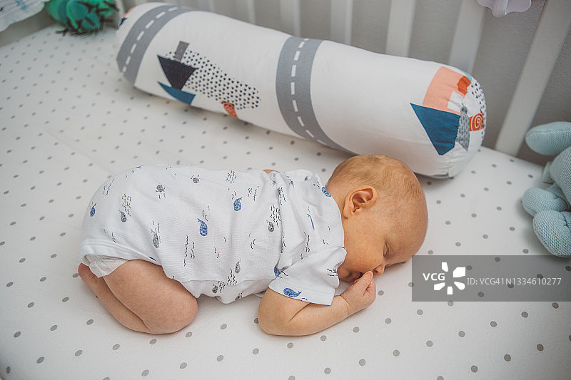 宝宝趴在婴儿床上睡觉图片素材