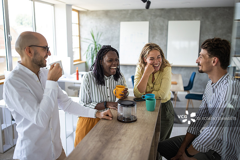 同事们在开放式工作场所享受咖啡休息时间图片素材