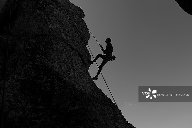 攀登悬崖岩石的健壮老人图片素材