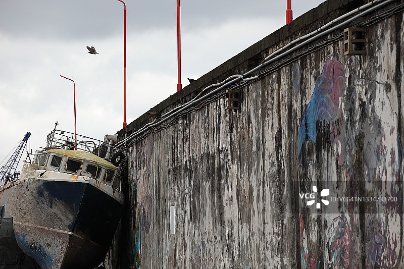 倚靠在墙边的旧船，阴天图片素材