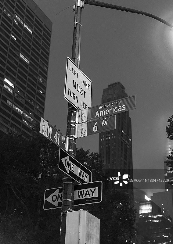 曼哈顿夜晚的拥挤路灯柱和多个路标图片素材