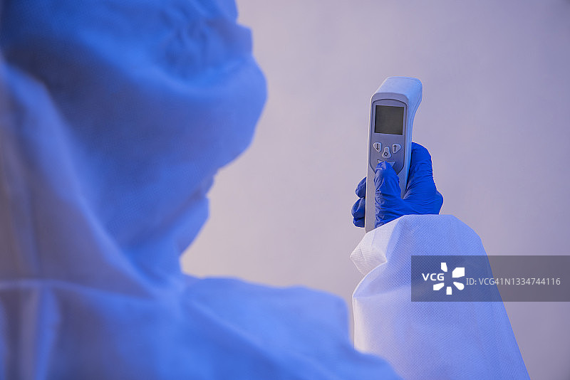 身穿防护服的医务人员手持测温枪图片素材