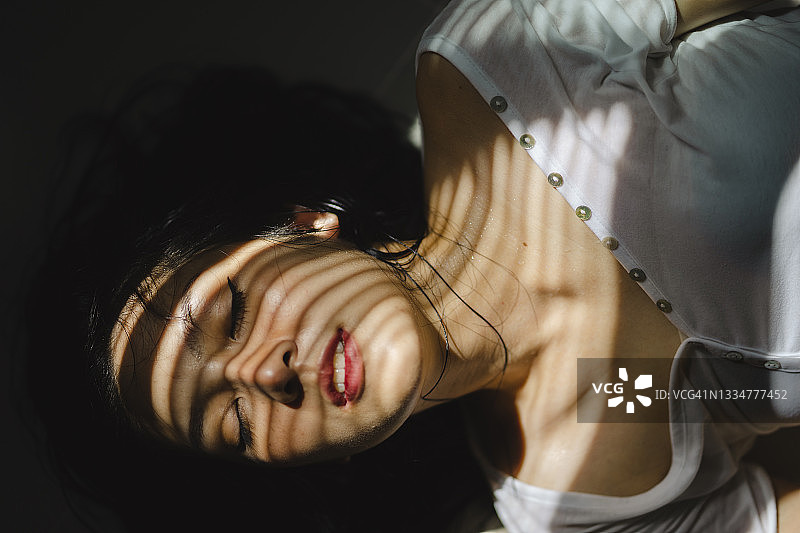 用高对比度的光影描绘亚洲女性积极的情感图片素材