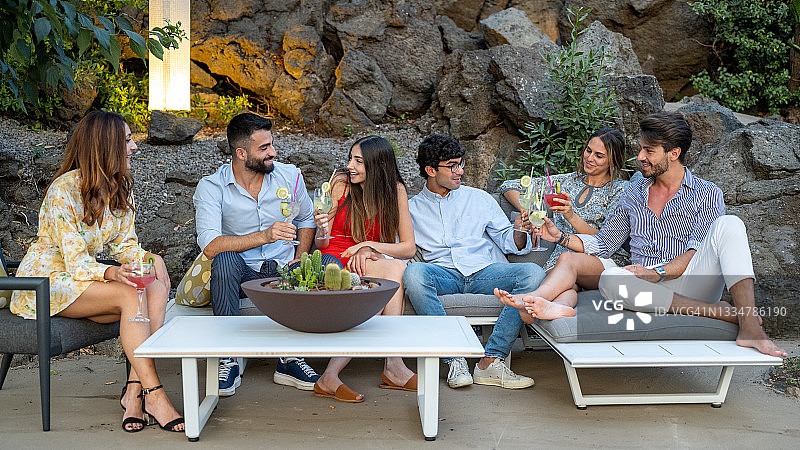 年轻人在鸡尾酒会上享受乐趣，优雅的人们在交谈和饮酒，30代的休闲时光图片素材