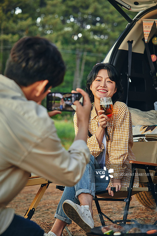 露营时为女友拍照的男友图片素材