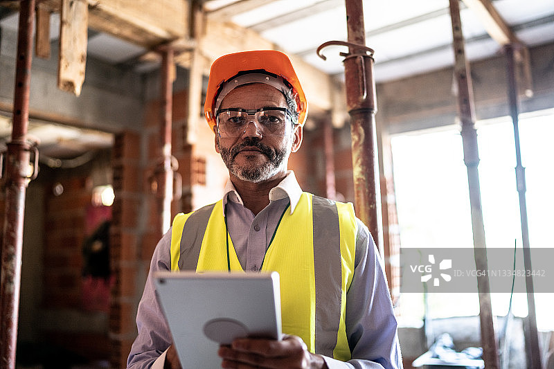 在建筑工地使用平板电脑工作的工程师肖像图片素材