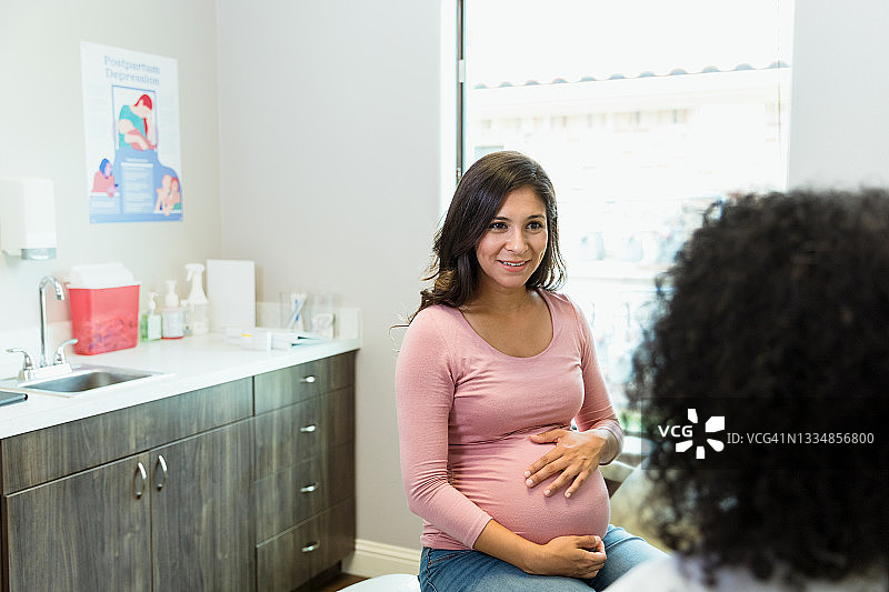 快乐的孕妇听取女医生的建议图片素材