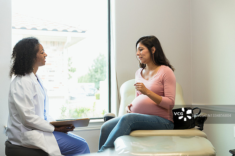 中年准妈妈就诊时向女医生提问图片素材