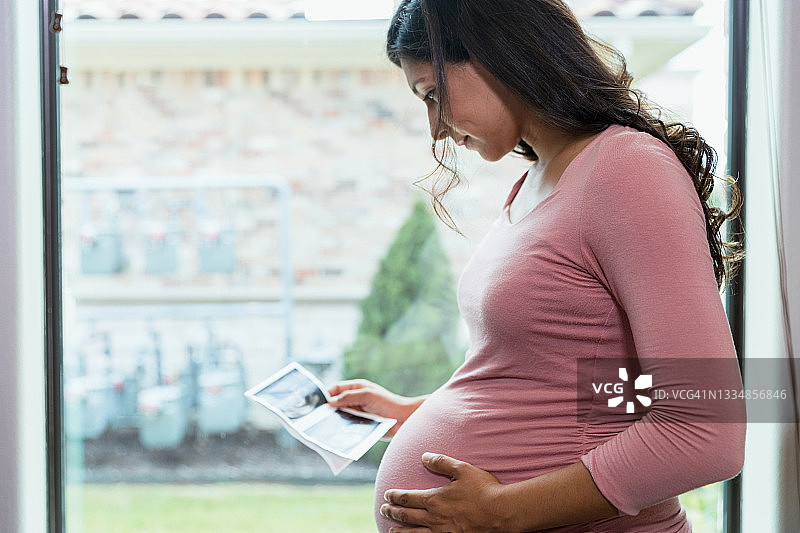 中年孕妇看着超声波照片图片素材