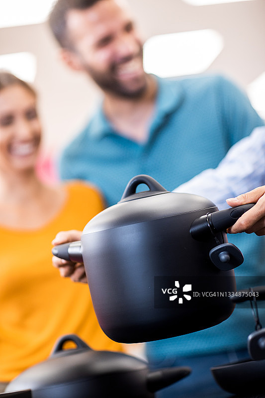 年轻夫妇接受女销售员的帮助图片素材