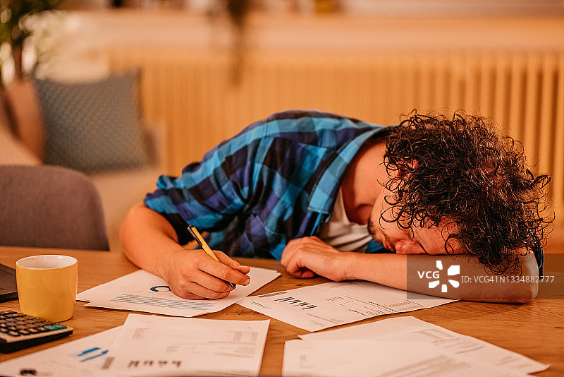 男子深夜在家工作时睡着图片素材