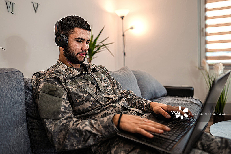 士兵坐在家里的沙发上图片素材