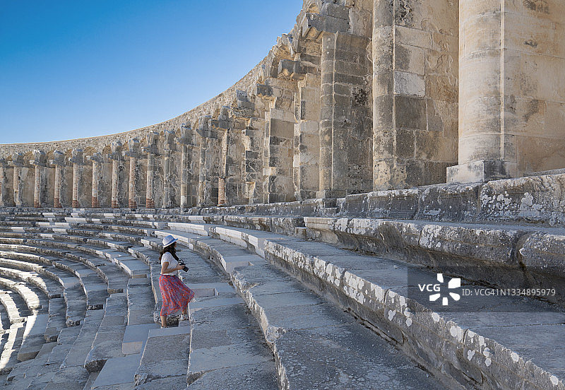 在土耳其安塔利亚阿斯潘多斯圆形剧场拍照的女性游客摄影师图片素材