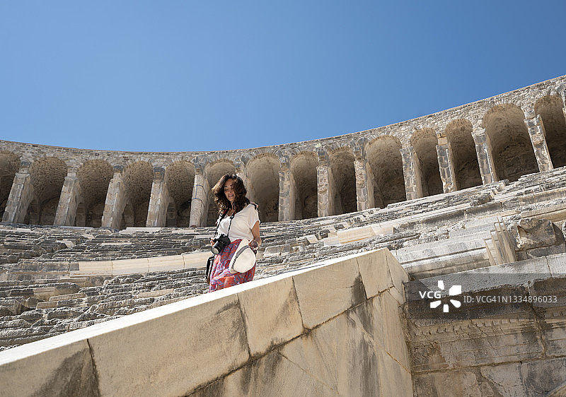 在土耳其安塔利亚阿斯潘多斯圆形剧场拍照的女性游客摄影师图片素材