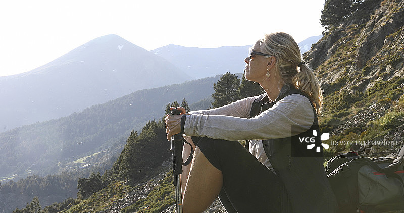 在阳光明媚的山脊上放松的女人图片素材