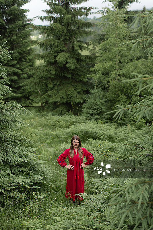 森林里穿着红色连衣裙的漂亮女人图片素材