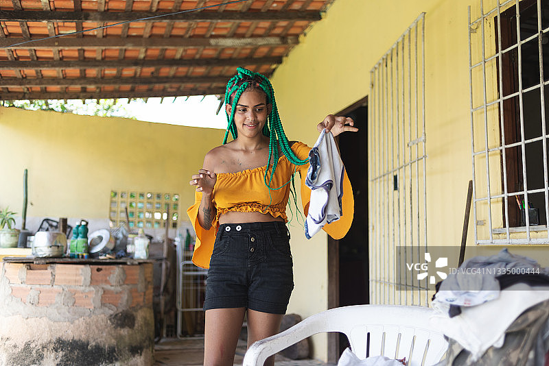 女人将脏衣服扔到待洗衣物堆上图片素材