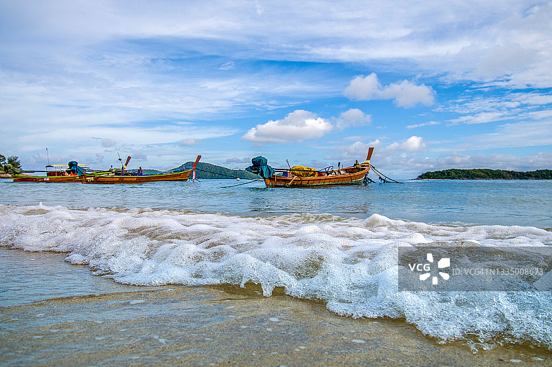 泰国普吉岛海滩上色彩鲜艳的渔船图片素材