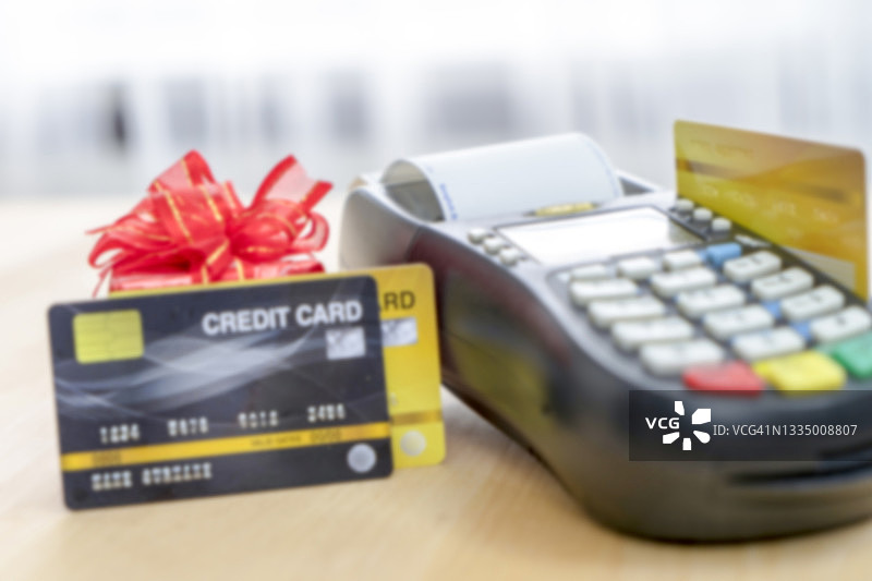 信用卡在EDC机器或信用卡终端上，配有计算器和眼镜（假信用卡，焦点模糊）图片素材
