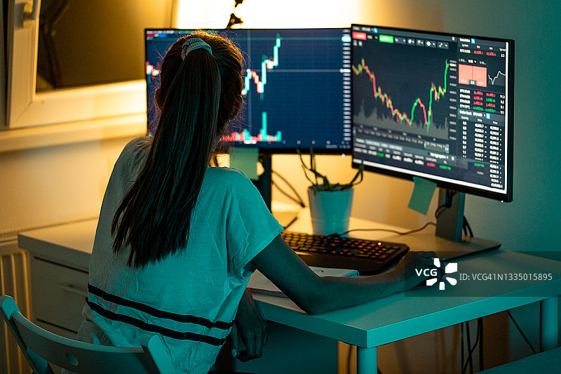 在电脑屏幕上看股市图表的女人图片素材